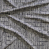 Close up of gently draped woven Indoor-Outdoor fabric with thin hand drawn stripe grid in ivory on navy. 