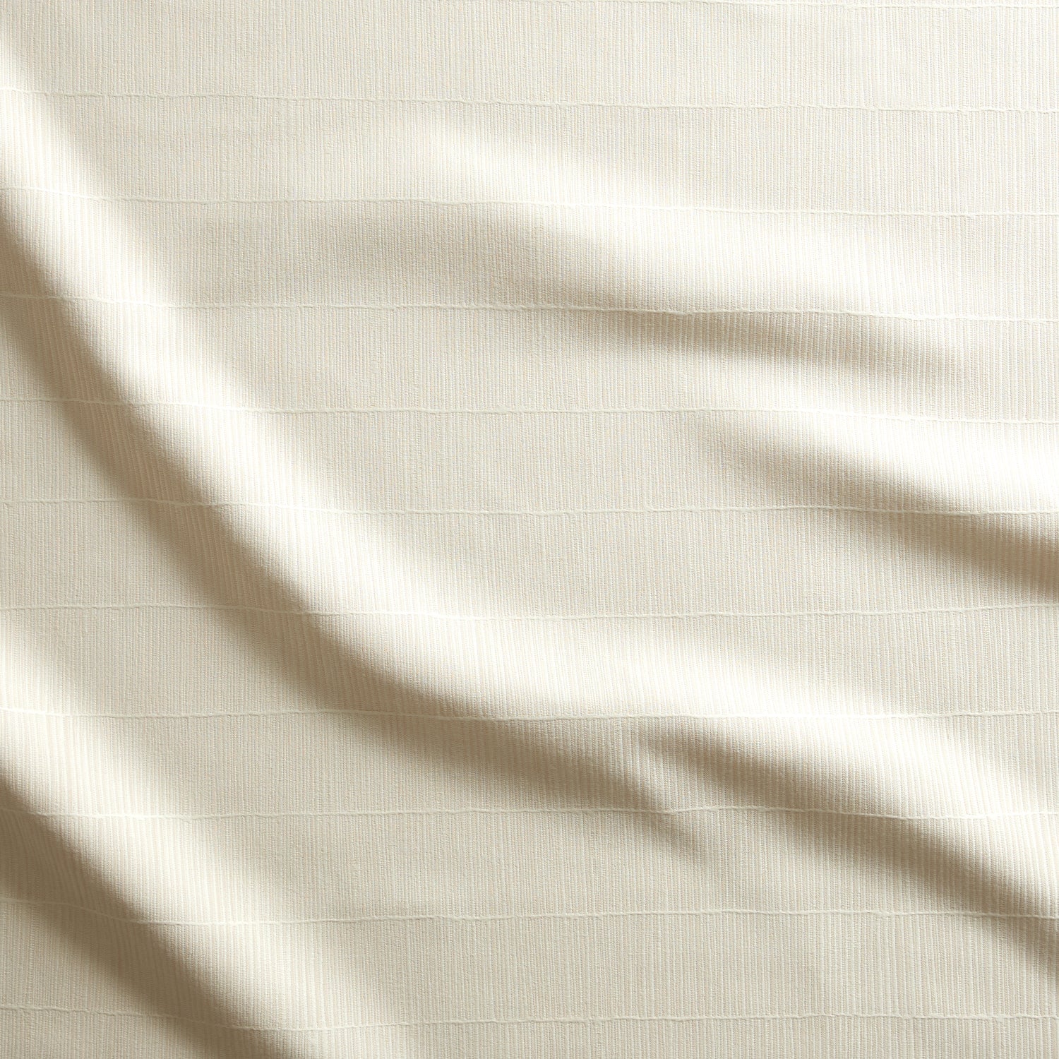 Close up of gently draped woven Indoor-Outdoor fabric with thin hand drawn stripe grid in ivory.