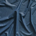 Close up of gently draped printed linen with thin hand drawn stripe grid in dark blue on navy blue.