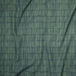 Close up of gently draped printed linen with thin hand drawn stripe grid in green on navy blue.