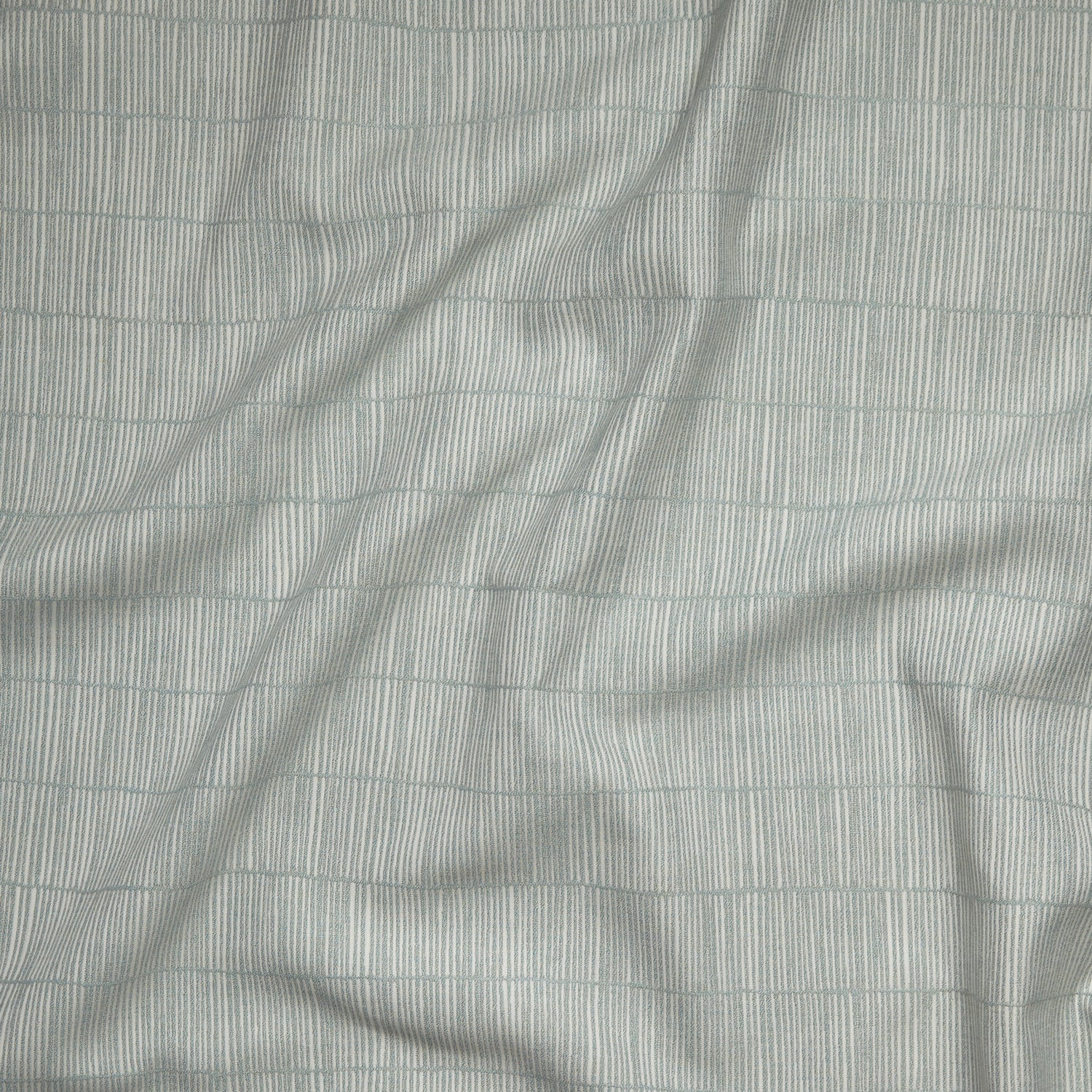 Close up of gently draped woven Indoor-Outdoor fabric with thin hand drawn stripe grid in ivory on sea foam blue.