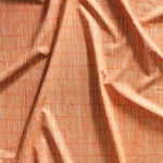 Close up of gently draped printed linen with thin hand drawn stripe grid in ivory on orange.