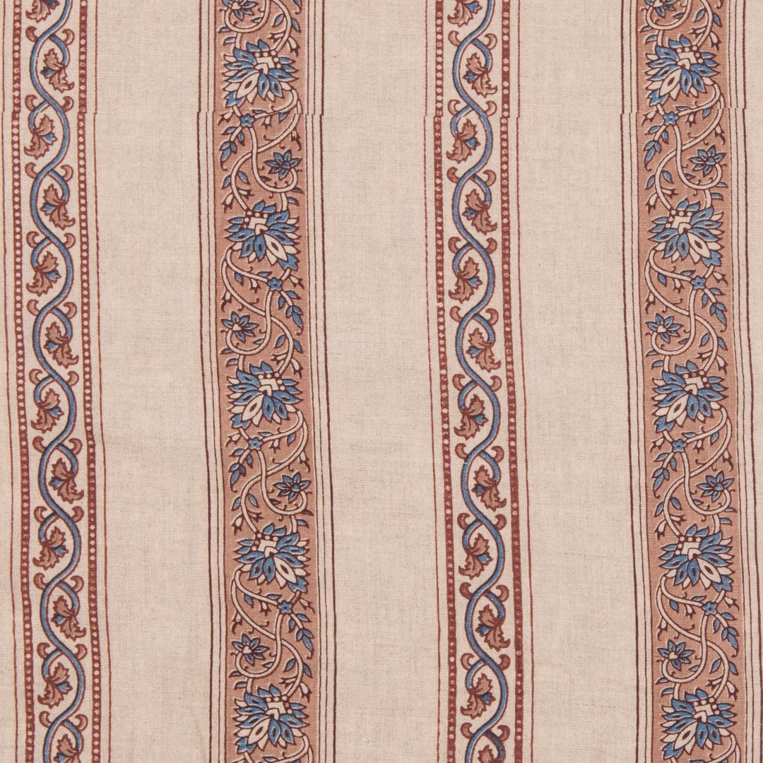 Detail of fabric in a striped paisley print in blue and brown on a cream field.