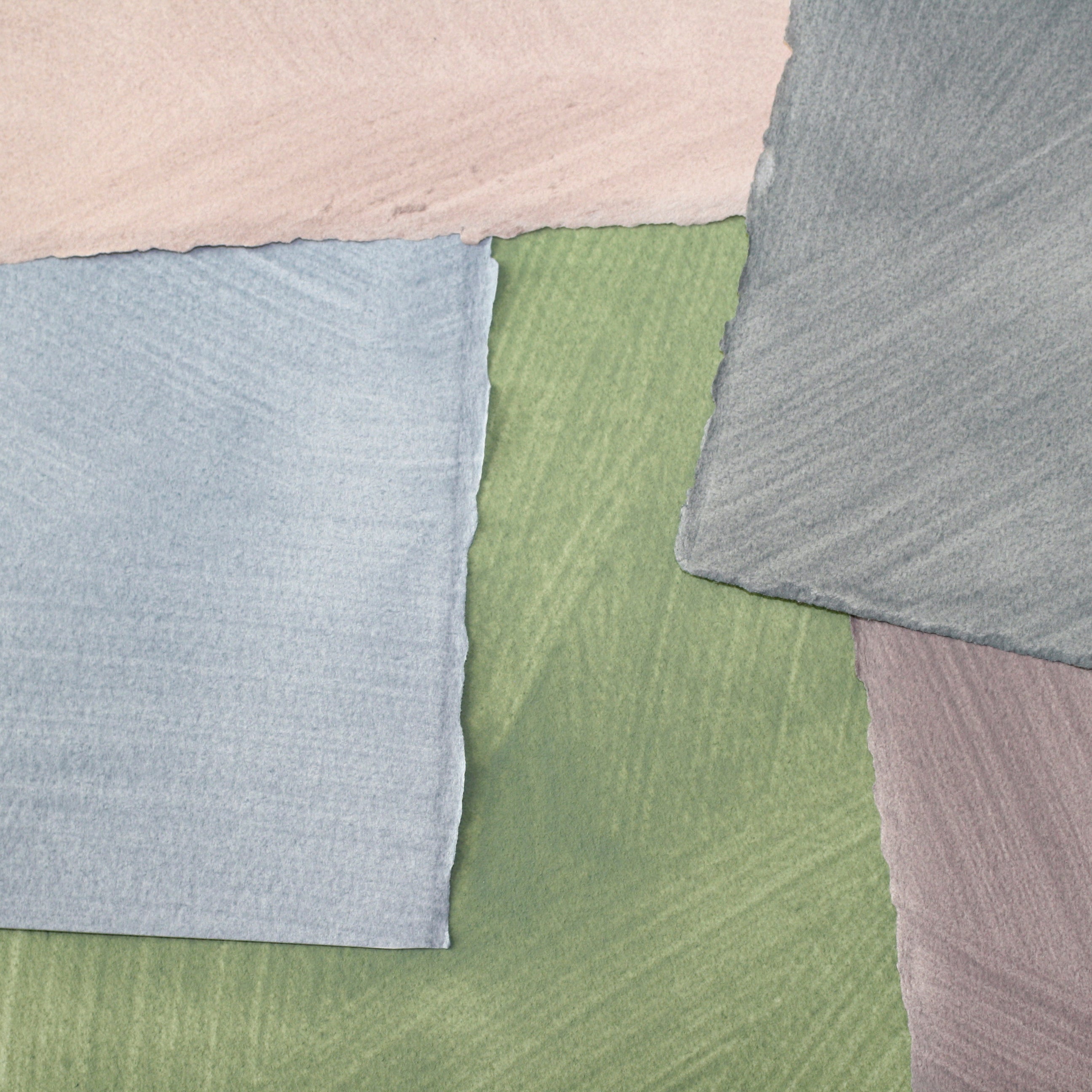 Pile of wallpaper swatches with irregular brushed patterns in shades of blue, green, gray and pink.
