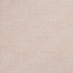 Detail of a printed linen fabric in a repeating camellia pattern in white on a light pink field.