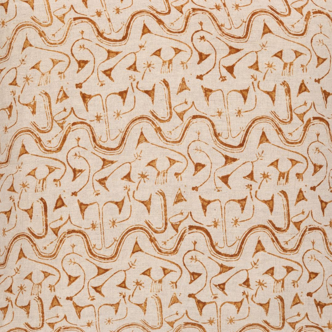 Detail of fabric in an abstract tribal print in orange on a tan field.
