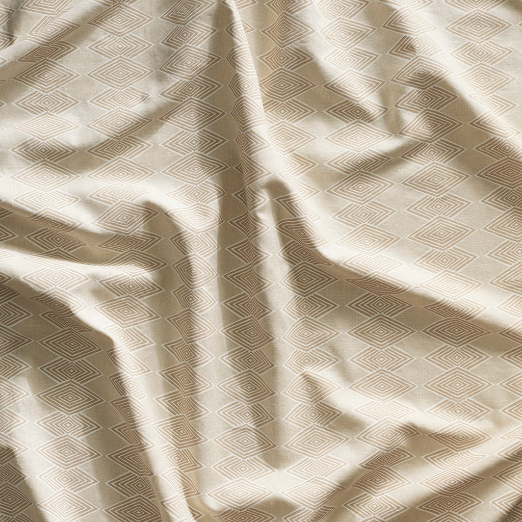 Close up of gently draped printed linen with linear stacked diamond stripe in shades of ecru.
