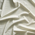 Close up of gently draped printed linen with linear stacked diamond stripe in shades of grey.