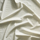 Close up of gently draped printed linen with linear stacked diamond stripe in shades of grey.
