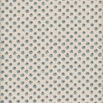 Detail of fabric in a painterly dot print in blue and brown on a cream field.
