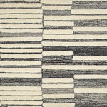 Broadloom carpet in a raised broken stripe pattern in cream on a charcoal grey field