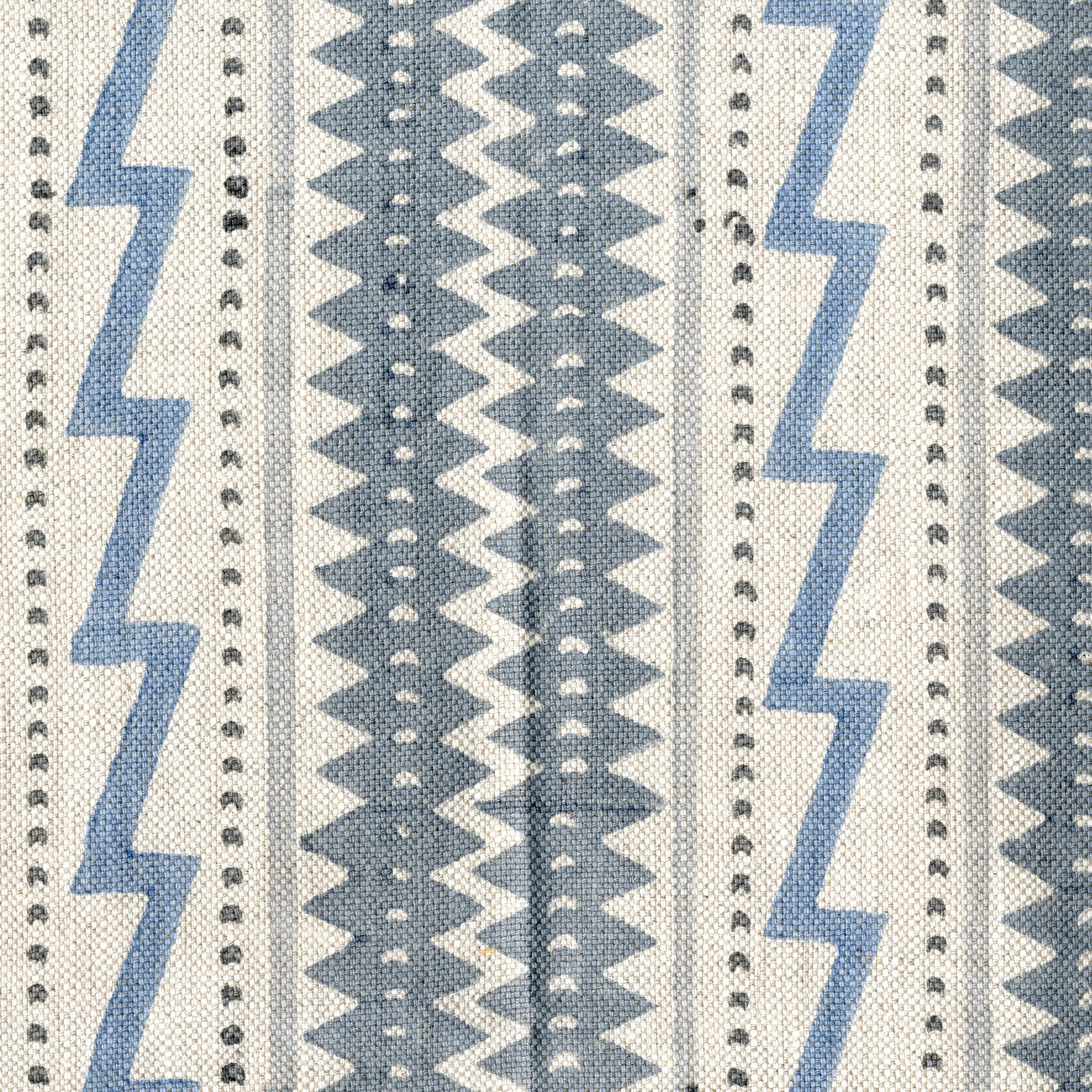 Fabric in a playful stripe and zigzag pattern in shades of gray and blue on a cream field.