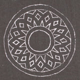 Detail of fabric in a repeating circular geometric print in white on a charcoal field.