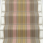 Striped flatweave runner in pink and sage on white staircase