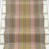 Striped flatweave runner in pink and sage on white staircase