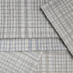 Pile of plaid broadloom swatches in neutral colors. 