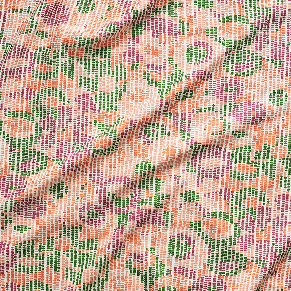 A close up of gently draped printed fabric with a pointillist abstract floral pattern in pink, purple, orange and green on white. 