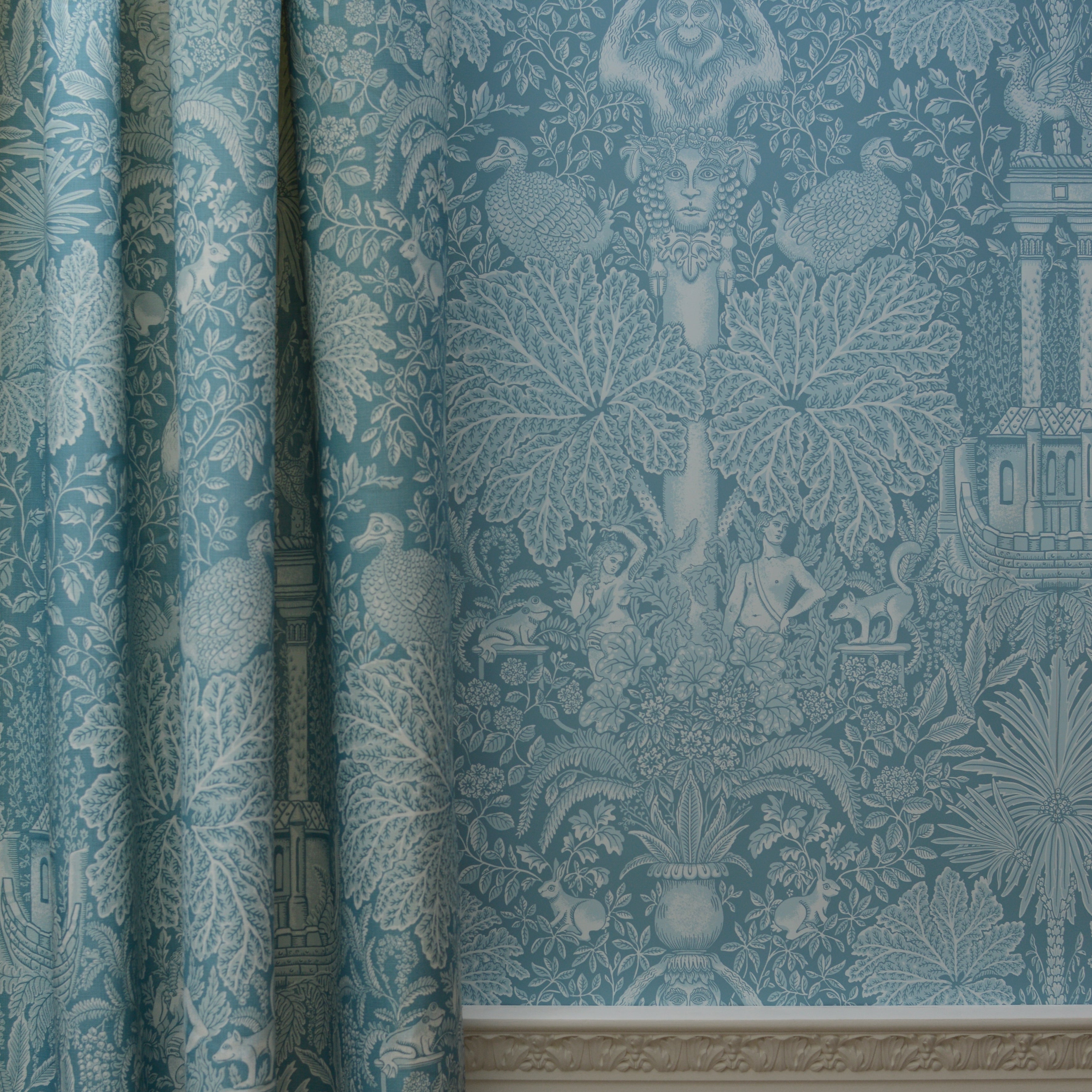 Teal patterned wallpaper with decorative design on a wall.