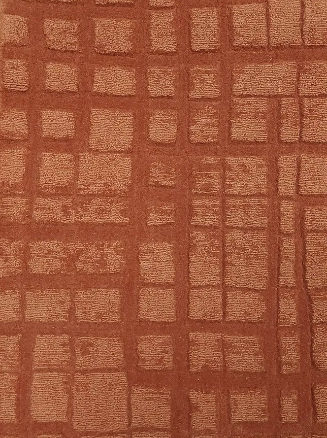 Broadloom carpet sample in a irregular plaid pattern in rust orange