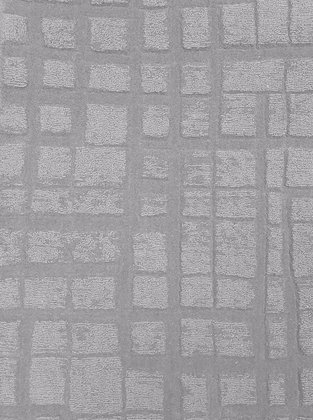 Broadloom carpet sample in a irregular plaid pattern in pale silver grey.