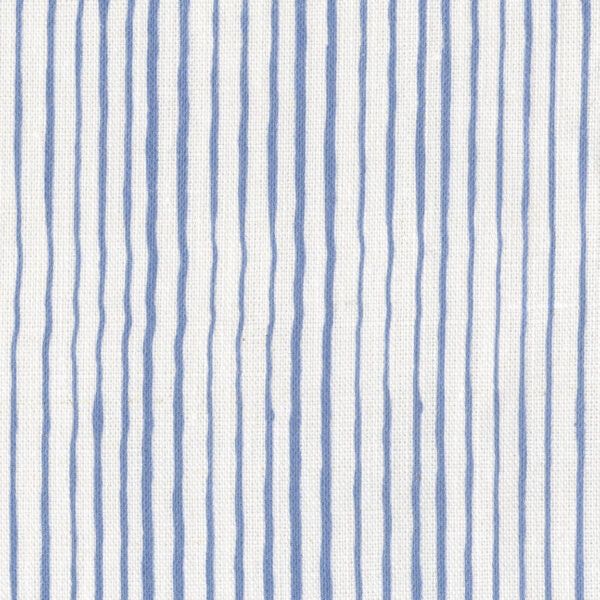 Fabric in a painterly stripe pattern in blue on a white field.