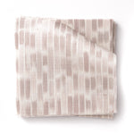 Stacked swatches of fabric in a linear check pattern in shades of pastel mauve on a white field.