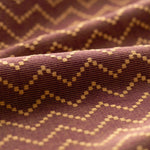 Close-up of fabric with a zigzag pattern on a brown background