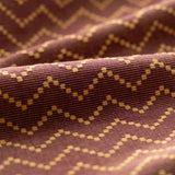 Close-up of fabric with a zigzag pattern on a brown background