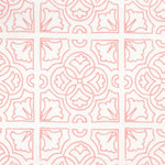 Detail of fabric in a damask lattice print in pink on a white field.