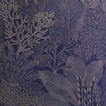 Detail of fabric in a dense coral print in gold on a navy field.
