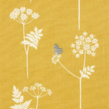 Detail of fabric in a playful flower and butterfly print in white and charcoal on a mustard field.