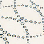 Fabric yardage in a playful floral lattice print in yellow and navy on a cream field.