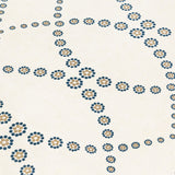 Fabric yardage in a playful floral lattice print in yellow and navy on a cream field.