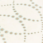 Fabric yardage in a playful floral lattice print in orange and turquoise on a cream field.