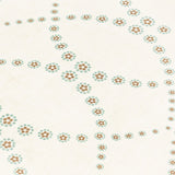 Fabric yardage in a playful floral lattice print in orange and turquoise on a cream field.