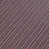 Detail of a wallpaper panel in a painterly herringbone print in pink on a navy field.