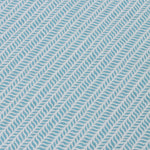 Detail of a wallpaper panel in a painterly herringbone print in sky blue on a light blue field.