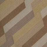 Detail of a handwoven rug with a stacked zig zag stripe in shades of brown, taupe, and tan. 