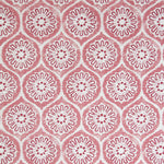 Detail of fabric in a floral lattice print in pink and red on a cream field.