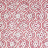 Detail of fabric in a floral lattice print in pink and red on a cream field.