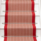 Striped flatweave runner in orange and red on white staircase