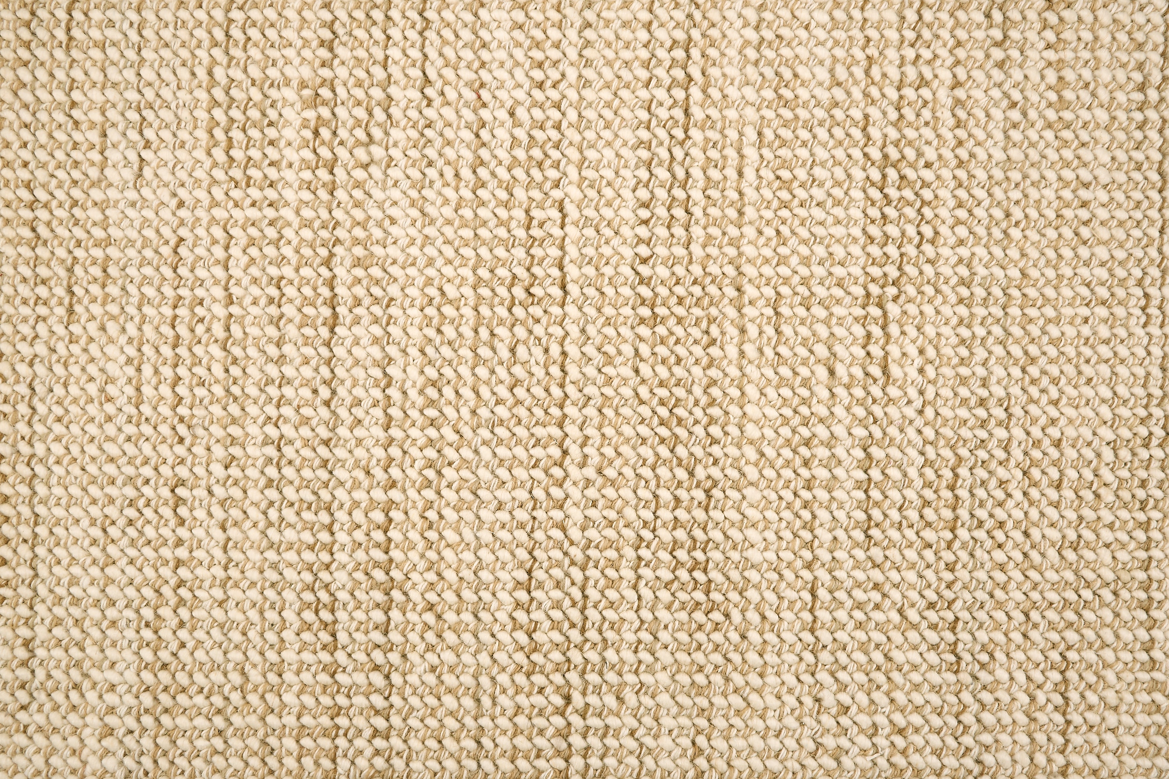 A close-up of a broadloom carpet with a woven texture in cream and tan.