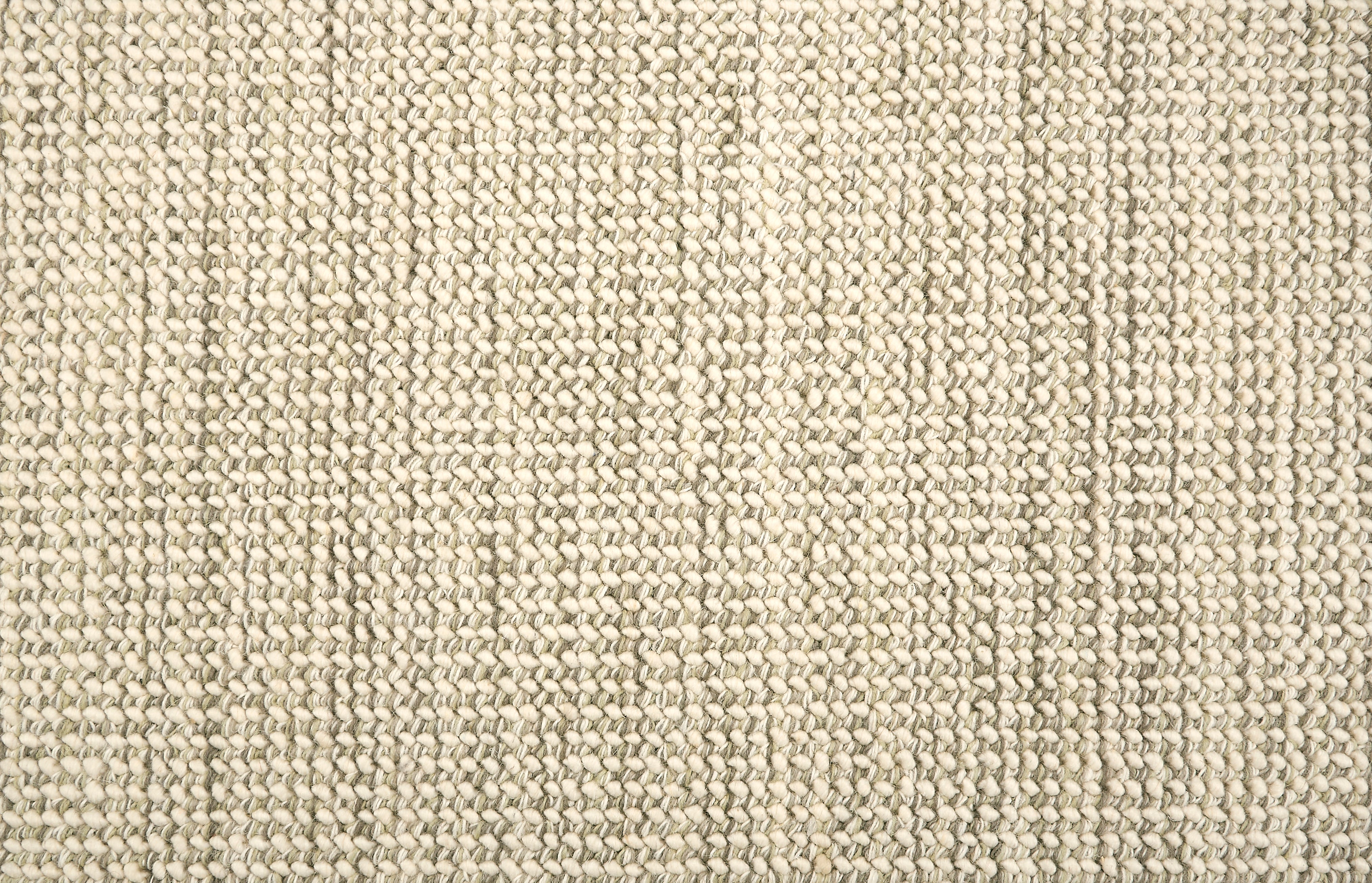 A close-up of a broadloom carpet with a woven texture in cream and grey. 