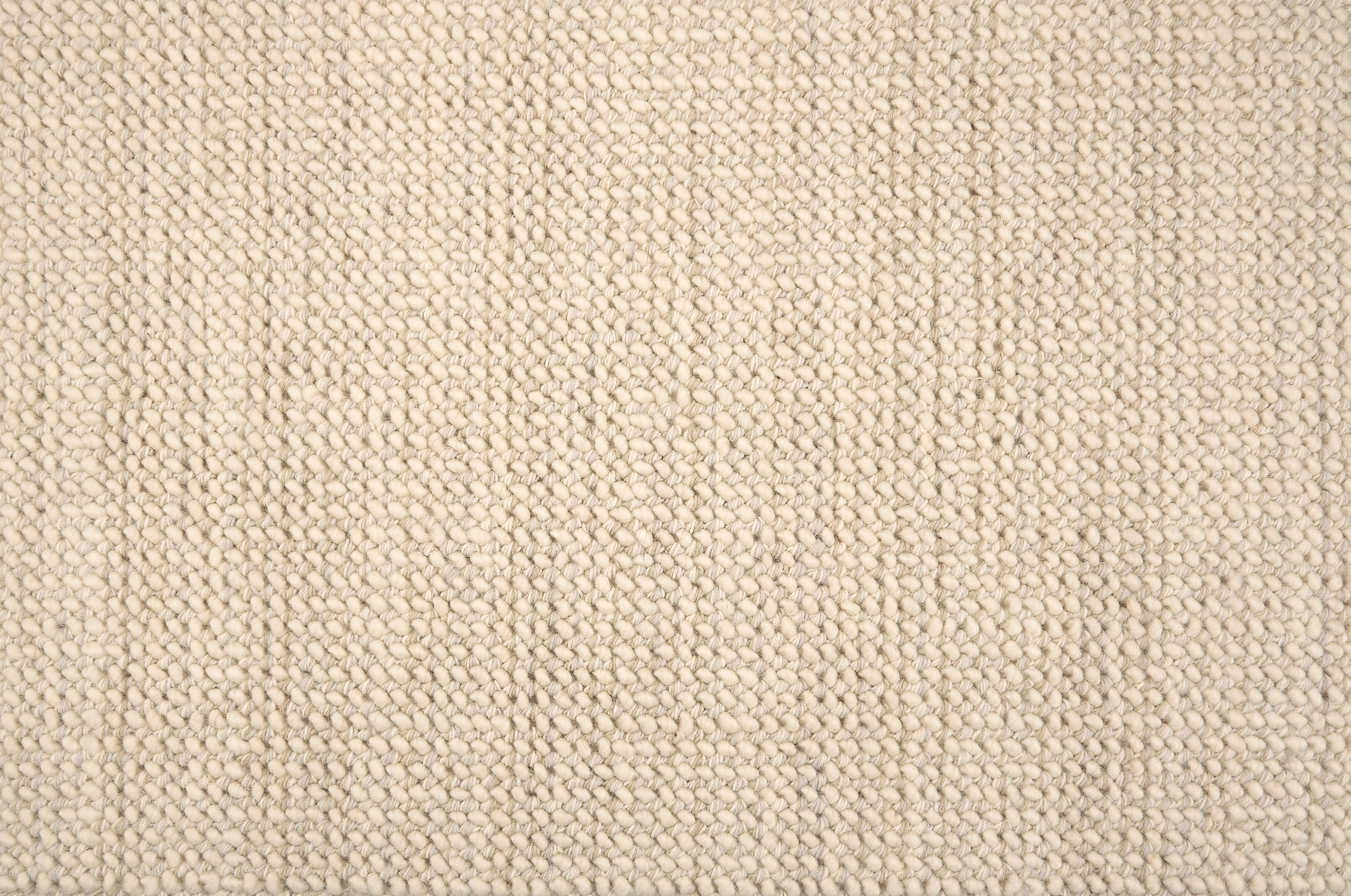 A close-up of a broadloom carpet with a woven texture in cream. 