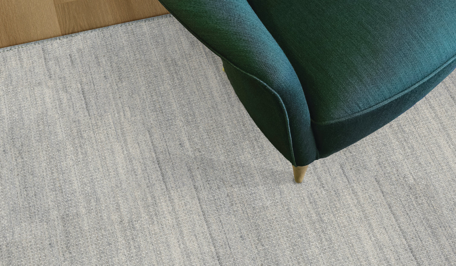 Green chair corner on a textured light gray carpet
