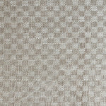 Close up of woven fabric with small scale checkerboard pattern in white and beige.
