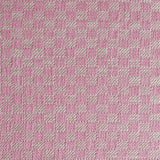 Close up of woven fabric with small scale checkerboard pattern in white and bright pink. 