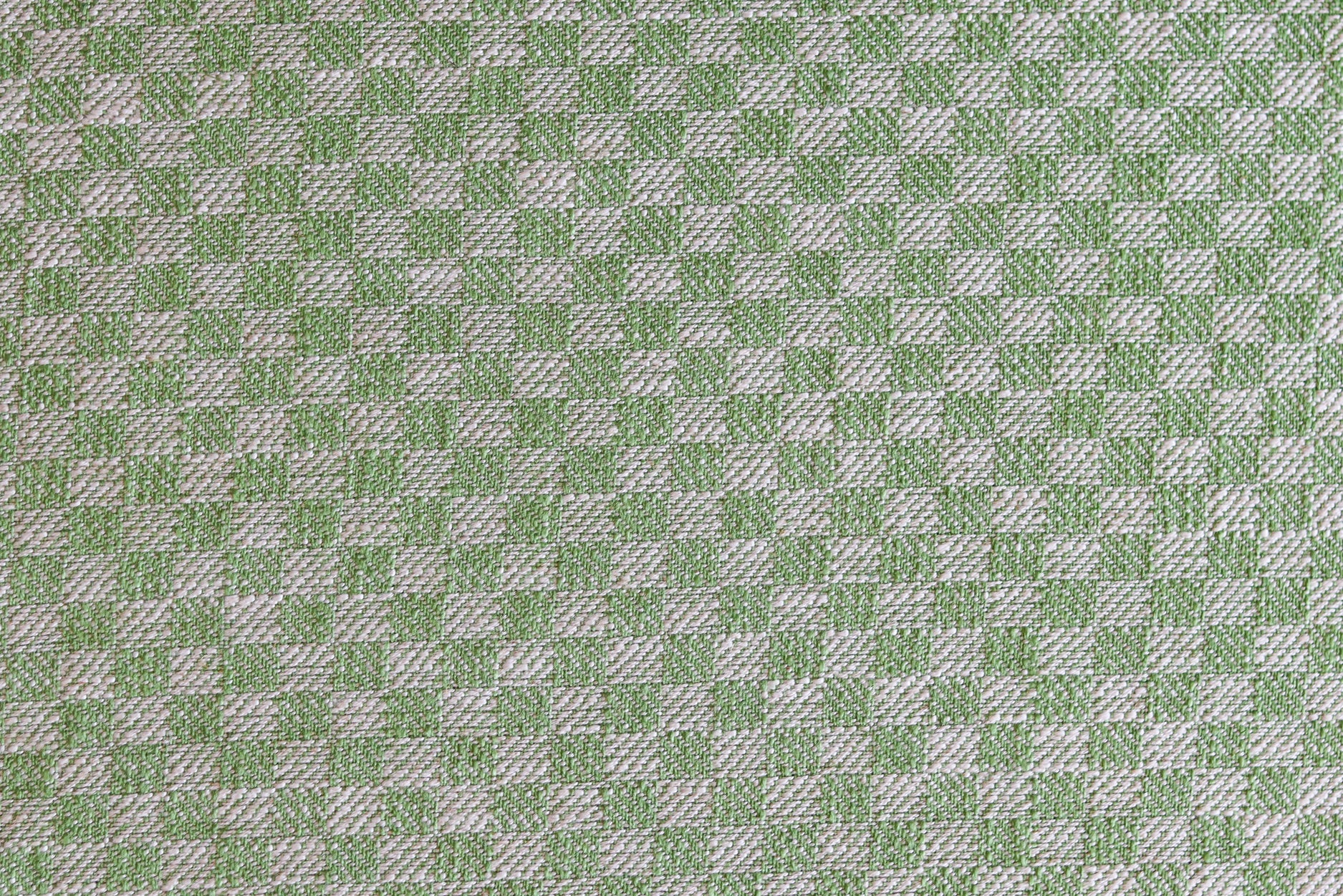 Close up of woven fabric with small scale checkerboard pattern in white and bright green. 