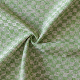 Close up of draped woven fabric with small scale checkerboard pattern in white and bright green. 