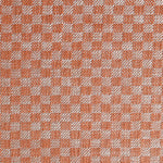 Close up of woven fabric with small scale checkerboard pattern in white and bright orange. 